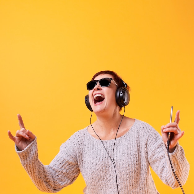 Femme aînée écoutant de la musique rock