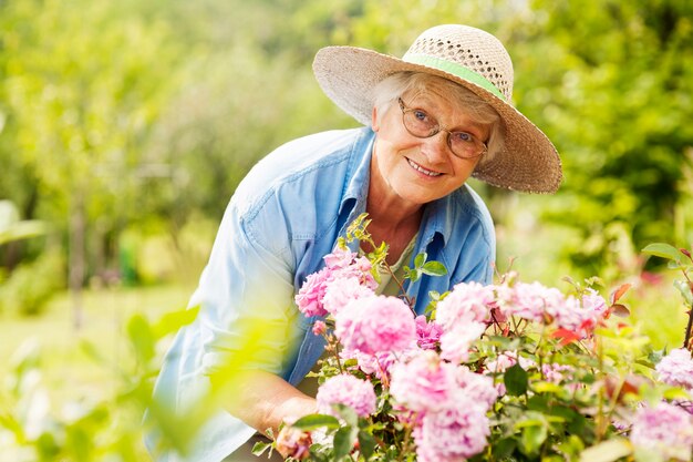 Femme aînée, à, fleurs, dans, jardin