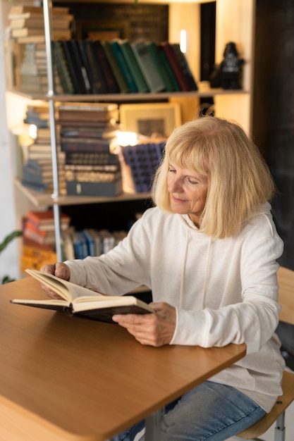 Femme aînée, lecture livre, chez soi