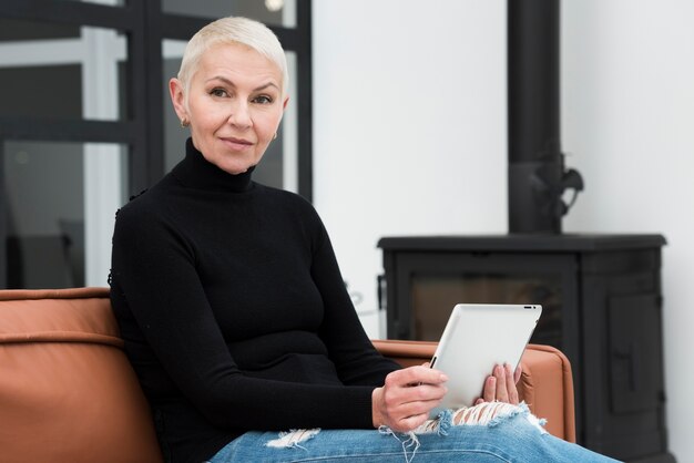 Femme aînée, à, tablette, délassant, sur, divan