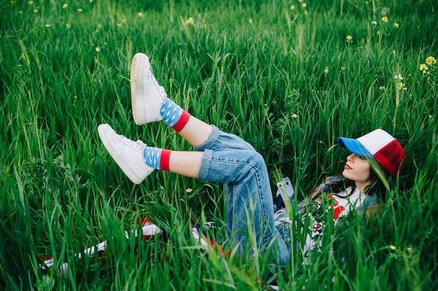 Femme allongée sur l&#39;herbe verte dans des vêtements colorés