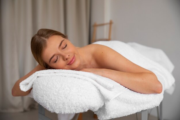 Femme allongée sur un lit de massage prêt pour la séance