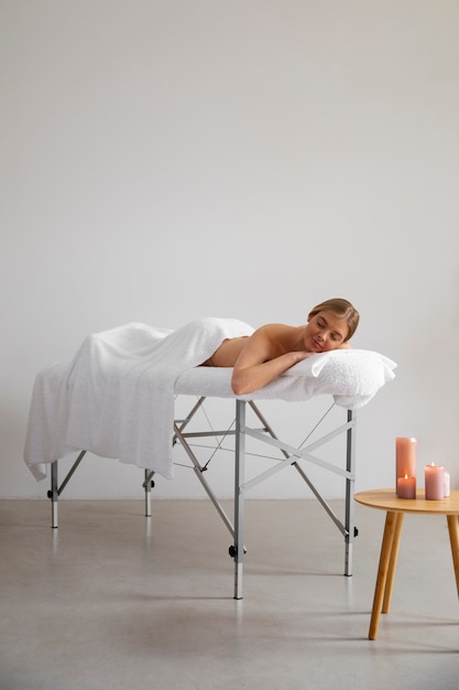 Femme allongée sur un lit de massage prêt pour la séance