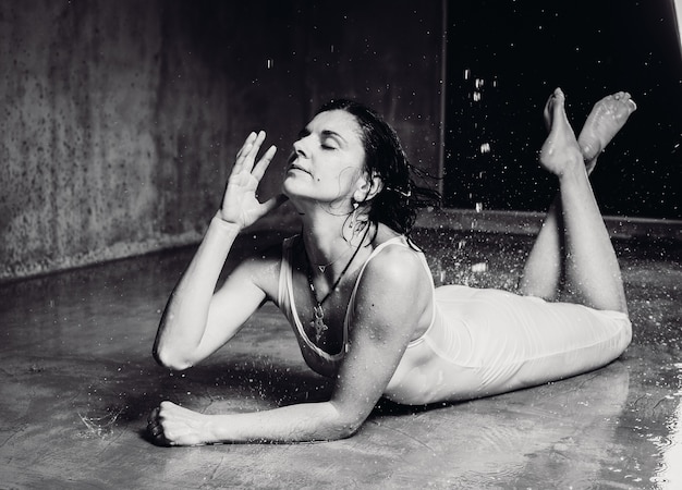 Femme allongée sur le sol pendant que l&#39;eau tombe sur elle