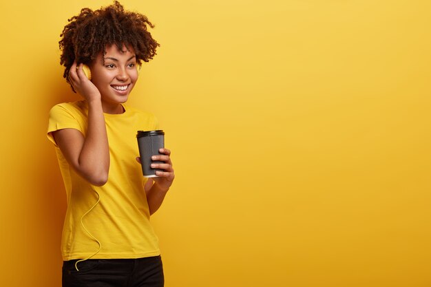 Femme américaine africaine, porter, t-shirt jaune, et, écouteurs