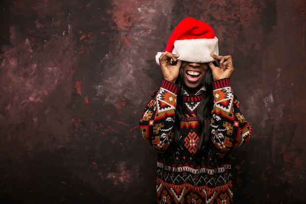 Femme américaine afro avec un chapeau rouge à Noël