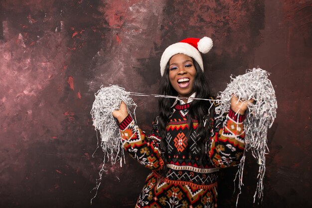 Femme américaine afro sur une fête de Noël avec des confettis