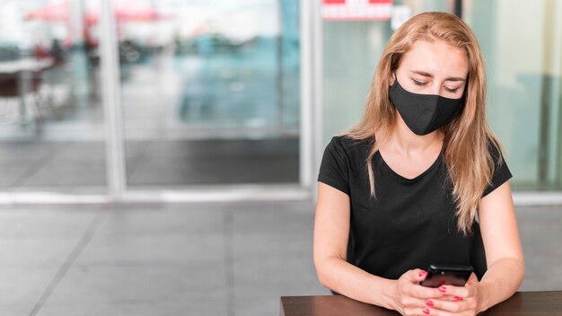 Femme à angle élevé au centre commercial portant un masque