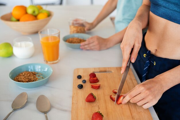 Photo gratuite femme à angle élevé coupant des fraises