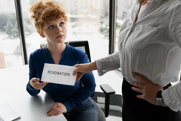 Femme à angle élevé recevant une note de démission