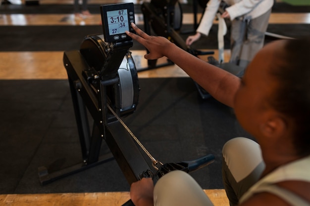 Photo gratuite femme à angle élevé s'entraînant au gymnase