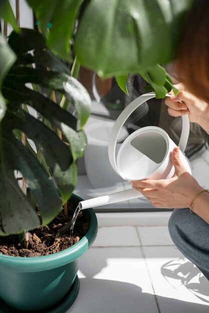 Femme à angle élevé tenant un arrosoir