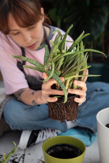 Photo gratuite femme à angle élevé transplantant une plante