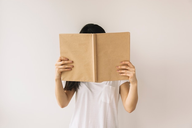 Femme anonyme, lecture, près, mur blanc