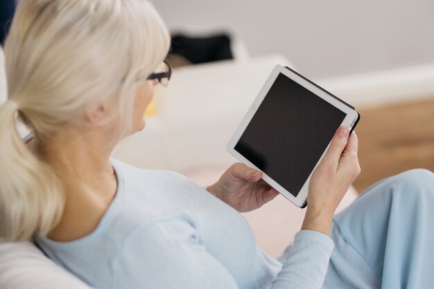 Femme anonyme, navigation tablette sur canapé