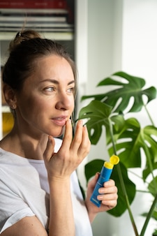 Femme appliquant un baume nourrissant hydratant sur ses lèvres pour éviter la sécheresse, les gerçures pendant la saison froide
