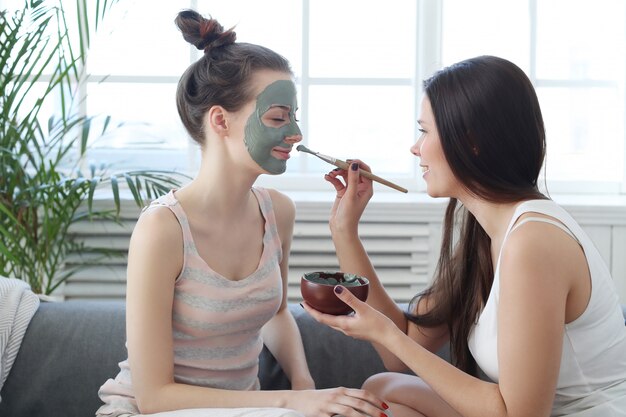 Femme appliquant un masque facial à son amie