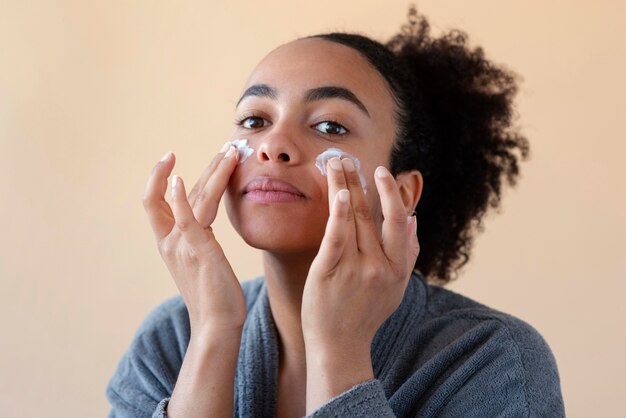 Femme, appliquer, crème visage, gros plan