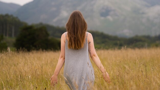 Femme appréciant le coucher du soleil nostalgique à la campagne