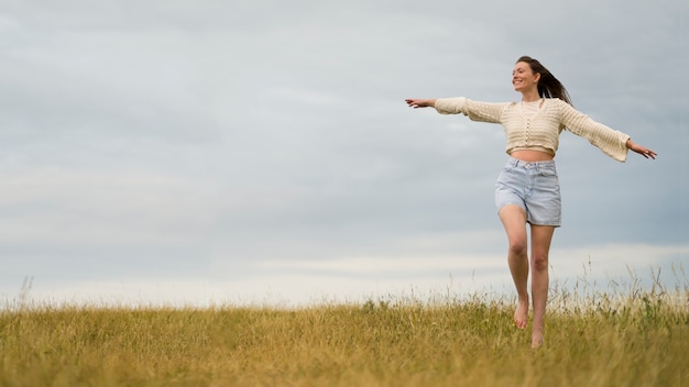 Femme appréciant le coucher du soleil nostalgique à la campagne