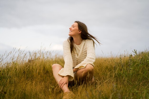 Femme appréciant le coucher du soleil nostalgique à la campagne