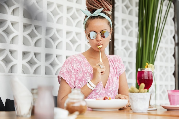 Femme appréciant le dessert et la boisson au café