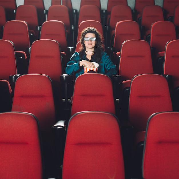 Femme appréciant le film dans l'auditorium vide