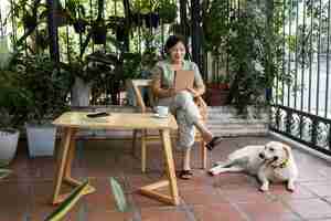 Photo gratuite femme appréciant un livre dans le jardin avec son chien