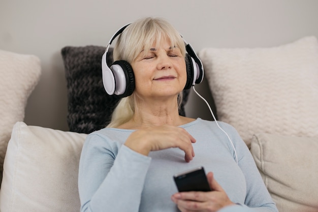 Femme appréciant la musique avec les yeux fermés