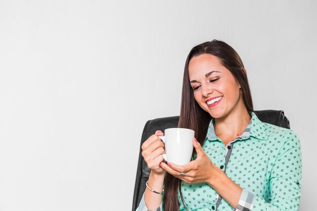 Femme appréciant sa tasse de café au bureau