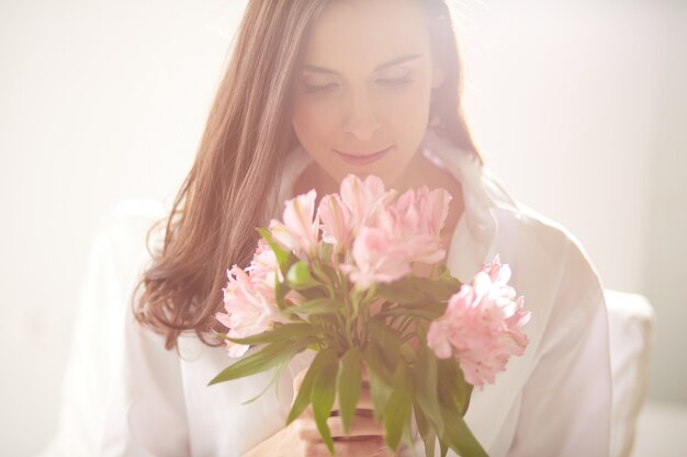 Femme appréciant et sentir un bouquet