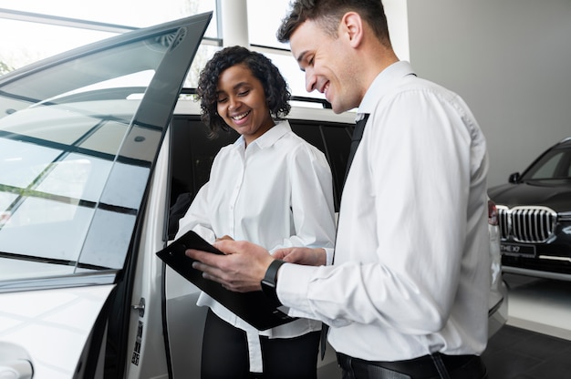 Femme appréciant son indépendance financière tout en achetant une voiture