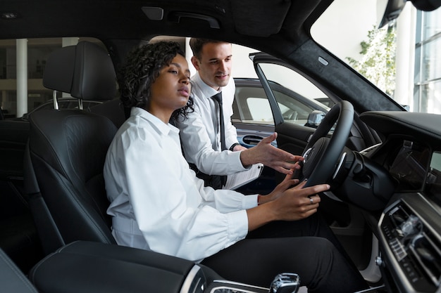 Photo gratuite femme appréciant son indépendance financière tout en achetant une voiture