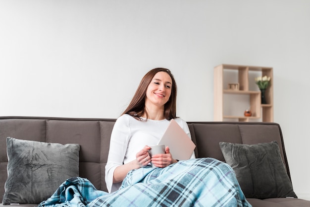 Femme appréciant son temps à la maison sur le canapé