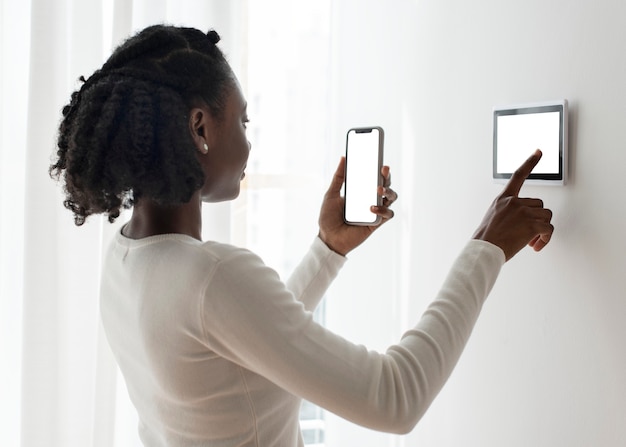 Femme appuyant sur le moniteur du panneau domotique intelligent