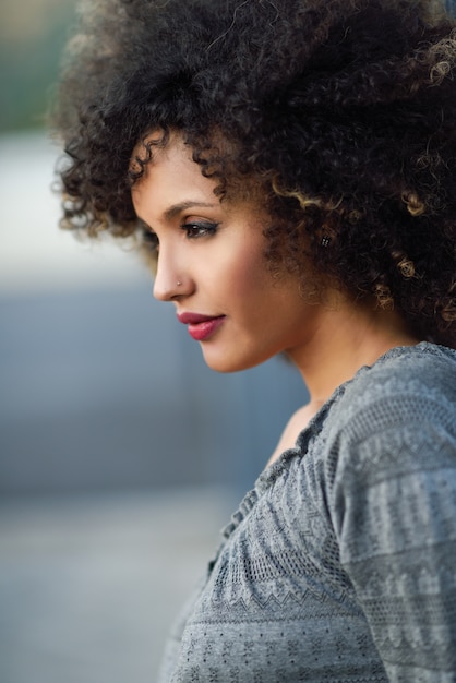 Photo gratuite femme appuyée contre un mur et arrière-plan flou