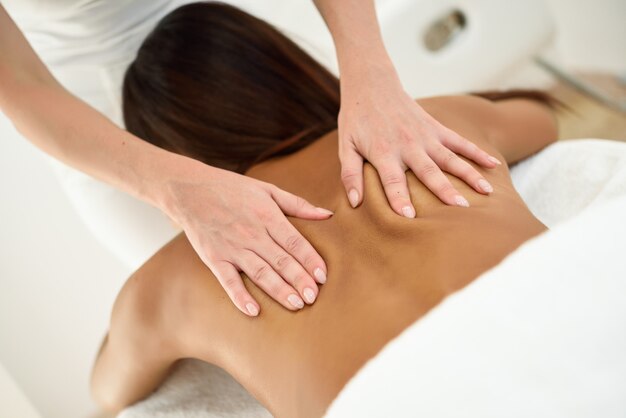 Femme arabe recevant un massage du dos dans un centre de bien-être spa.