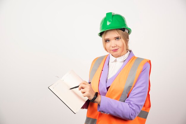 femme architecte en casque avec tablette sur blanc.