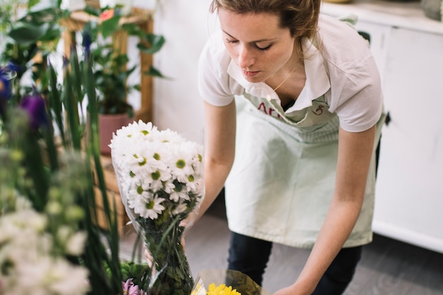 Photo gratuite femme arrangeant des fleurs dans la boutique