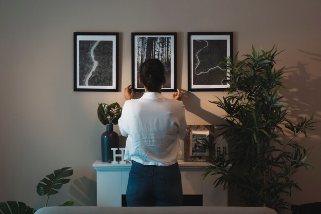 Femme arrangeant des peintures à la maison