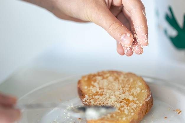 Photo gratuite une femme arrose un morceau de pain avec du fromage râpé un délicieux petit déjeuner