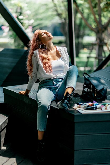 femme, artiste appréciant, se relaxant tout en étant assis dans un belvédère moderne dans le parc