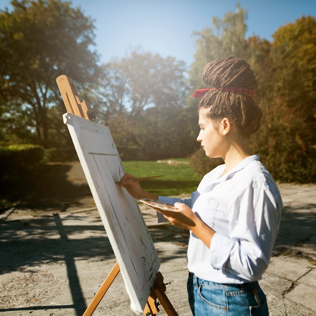 Photo gratuite femme artiste peignant en plein air