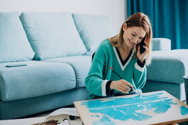 Femme artiste peignant un tableau à la maison