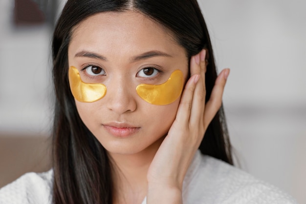 Femme asiatique à l'aide de patchs oculaires