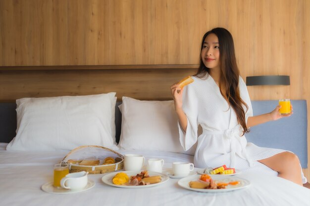 femme asiatique, apprécier, à, petit déjeuner, lit