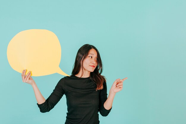 Femme asiatique avec bulle de dialogue pointant vers la droite