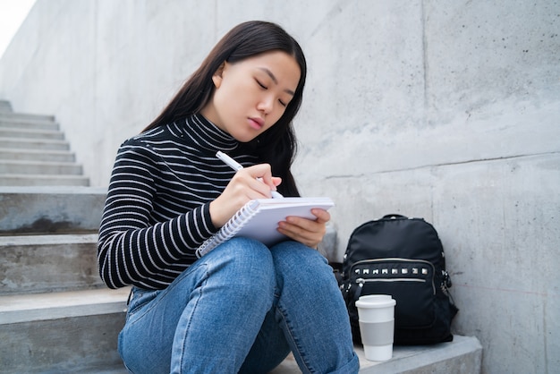 Femme asiatique écrit sur ordinateur portable.