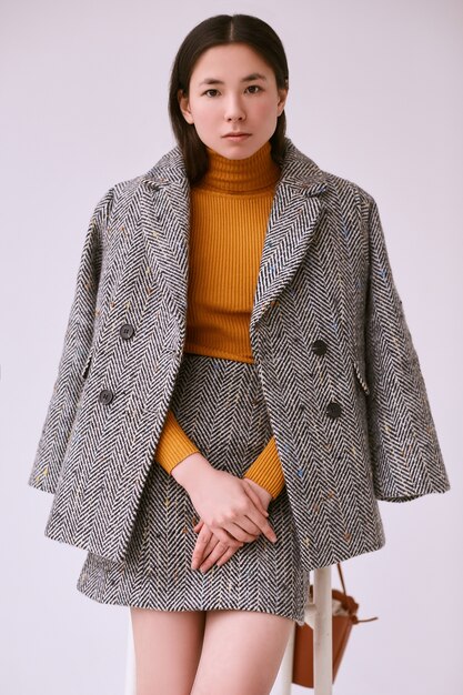Femme asiatique élégante en manteau de laine à la mode et jupe classique