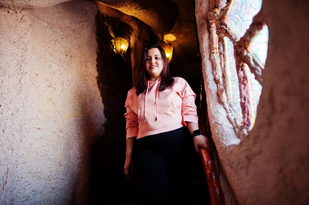 Femme asiatique élégante en tenue décontractée debout à l'intérieur de la maison près de la fenêtre